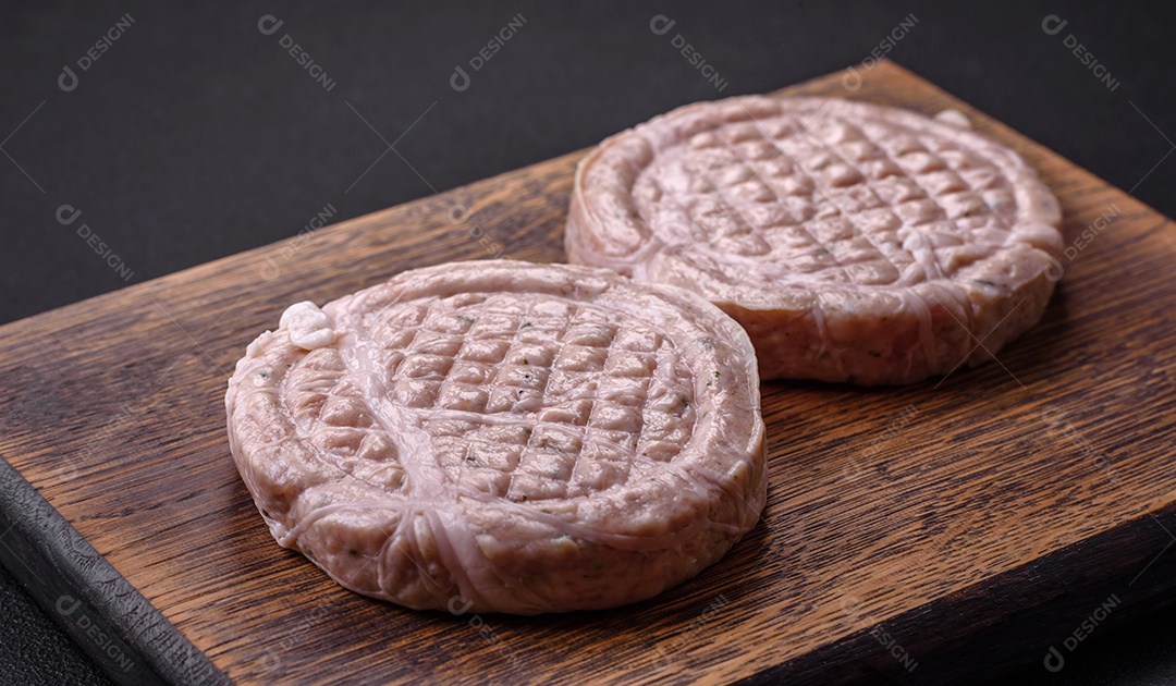 Almôndegas de carne crua com especiarias e ervas ou crepinette sobre um fundo escuro de concreto