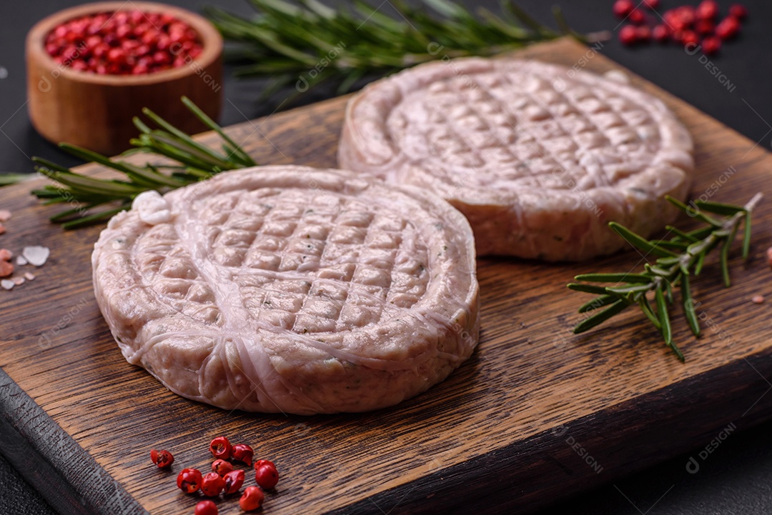 Almôndegas de carne crua com especiarias e ervas ou crepinette sobre um fundo escuro de concreto