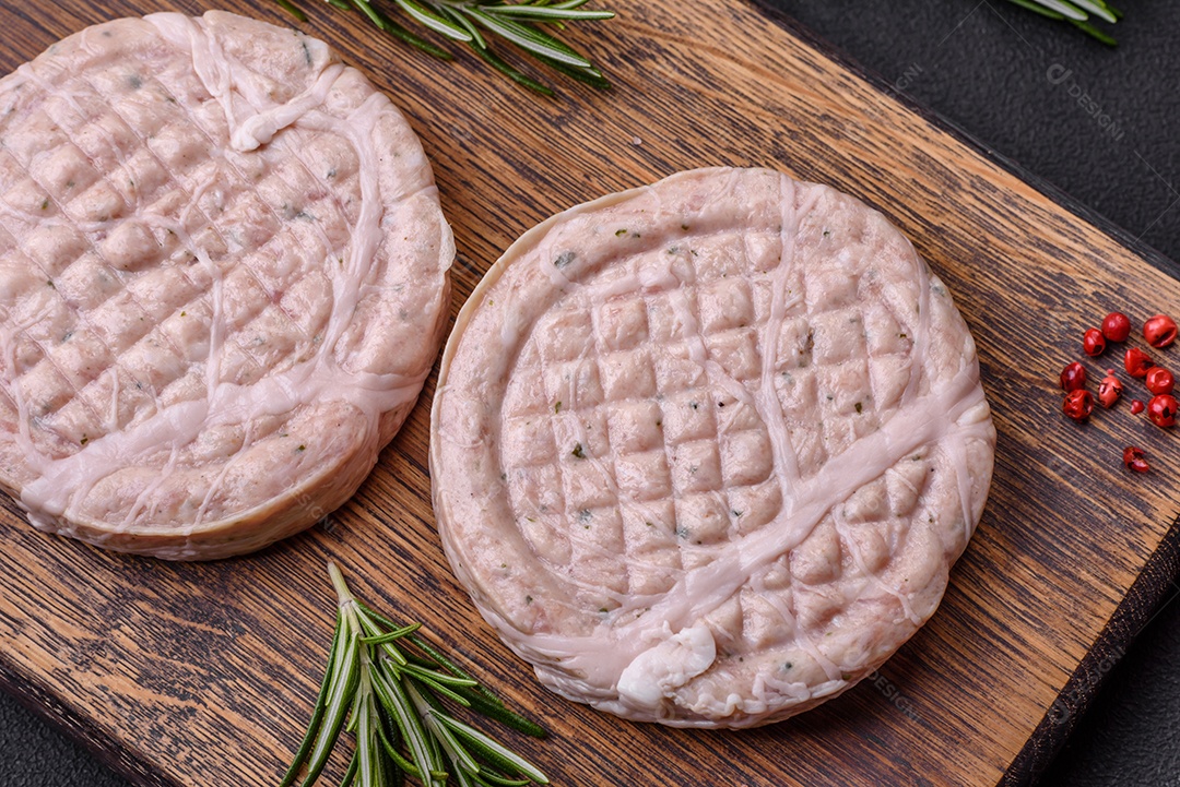 Almôndegas de carne crua com especiarias e ervas ou crepinette sobre um fundo escuro de concreto