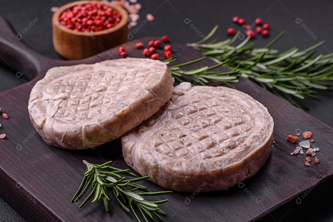 Almôndegas de carne crua com especiarias e ervas ou crepinette sobre um fundo escuro de concreto