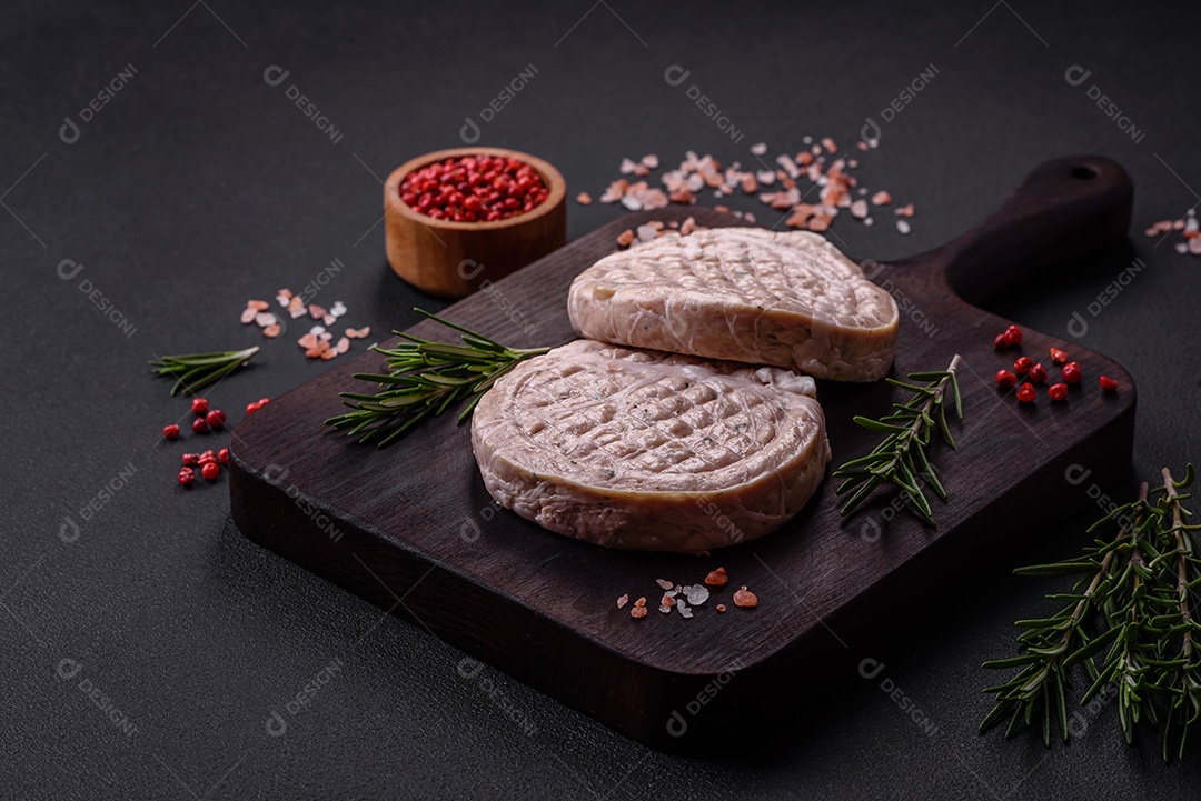 Almôndegas de carne crua com especiarias e ervas ou crepinette sobre um fundo escuro de concreto