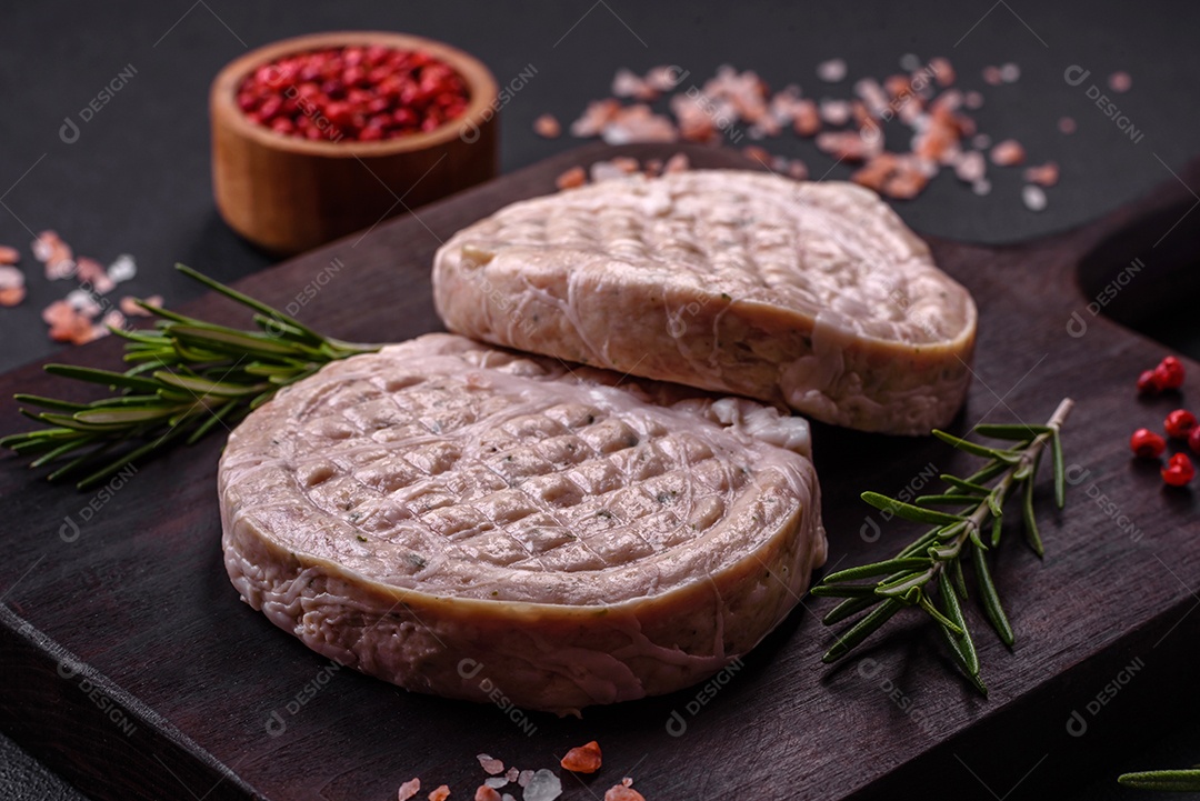 Almôndegas de carne crua com especiarias e ervas ou crepinette sobre um fundo escuro de concreto