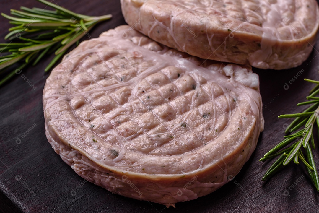 Almôndegas de carne crua com especiarias e ervas ou crepinette sobre um fundo escuro de concreto