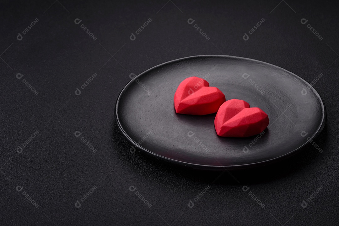 Deliciosos bombons de chocolate em forma de coração em um fundo escuro de concreto. Comemoração do dia dos namorados