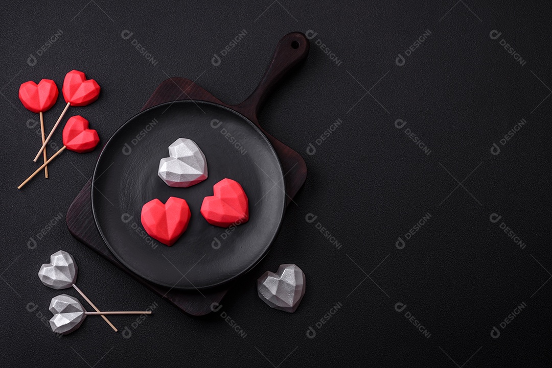 Deliciosos bombons de chocolate em forma de coração em um fundo escuro de concreto. Comemoração do dia dos namorados