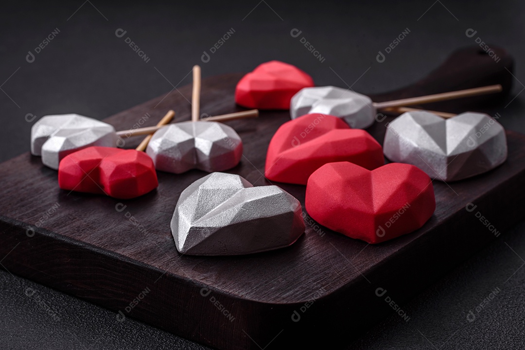 Deliciosos bombons de chocolate em forma de coração em um fundo escuro de concreto. Comemoração do dia dos namorados