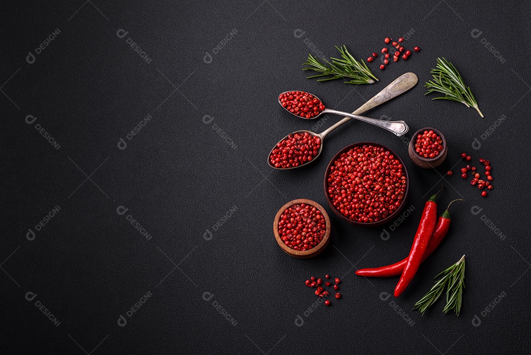 Especiarias, ervilhas de pimenta da Jamaica na cor vermelha ou rosa em uma tigela de madeira sobre um fundo preto de concreto. Cozinha asiática