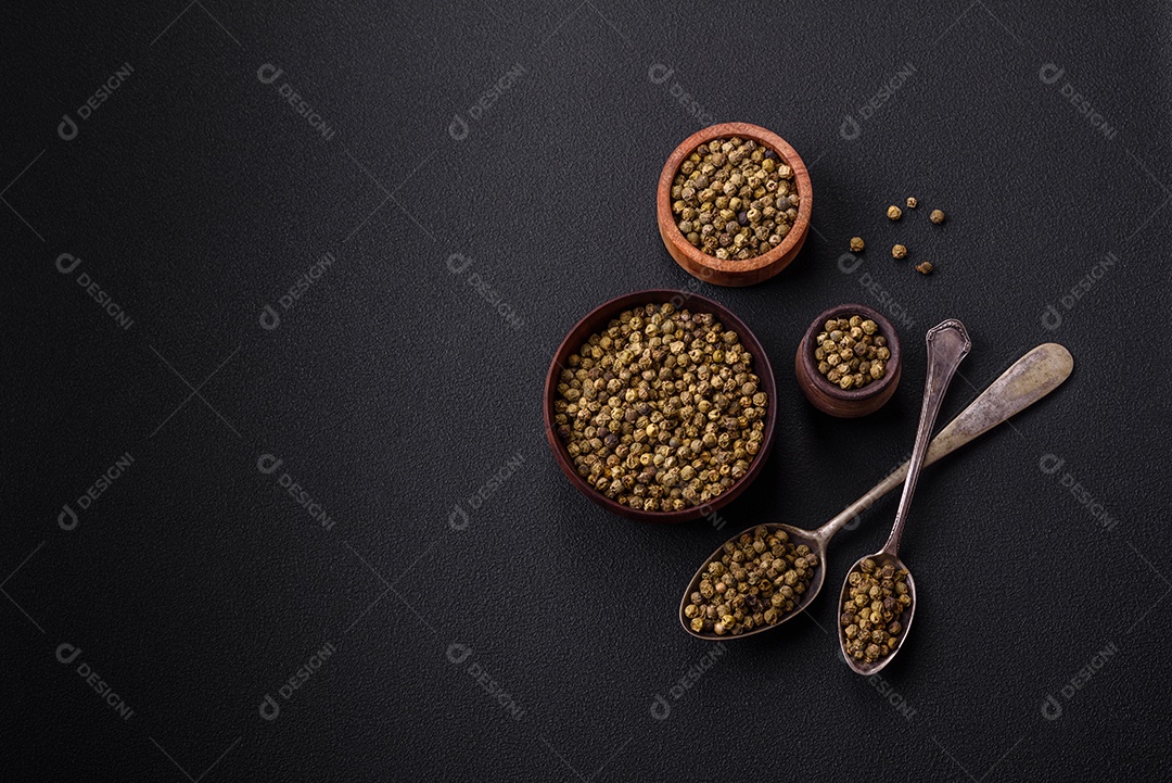 Especiarias, pimenta da Jamaica verde em uma tigela de madeira sobre um fundo preto de concreto. Cozinha asiática