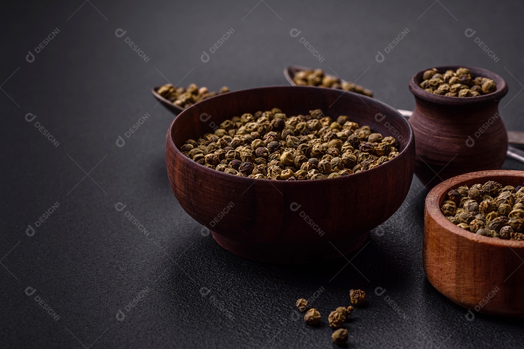 Especiarias, pimenta da Jamaica verde em uma tigela de madeira sobre um fundo preto de concreto. Cozinha asiática
