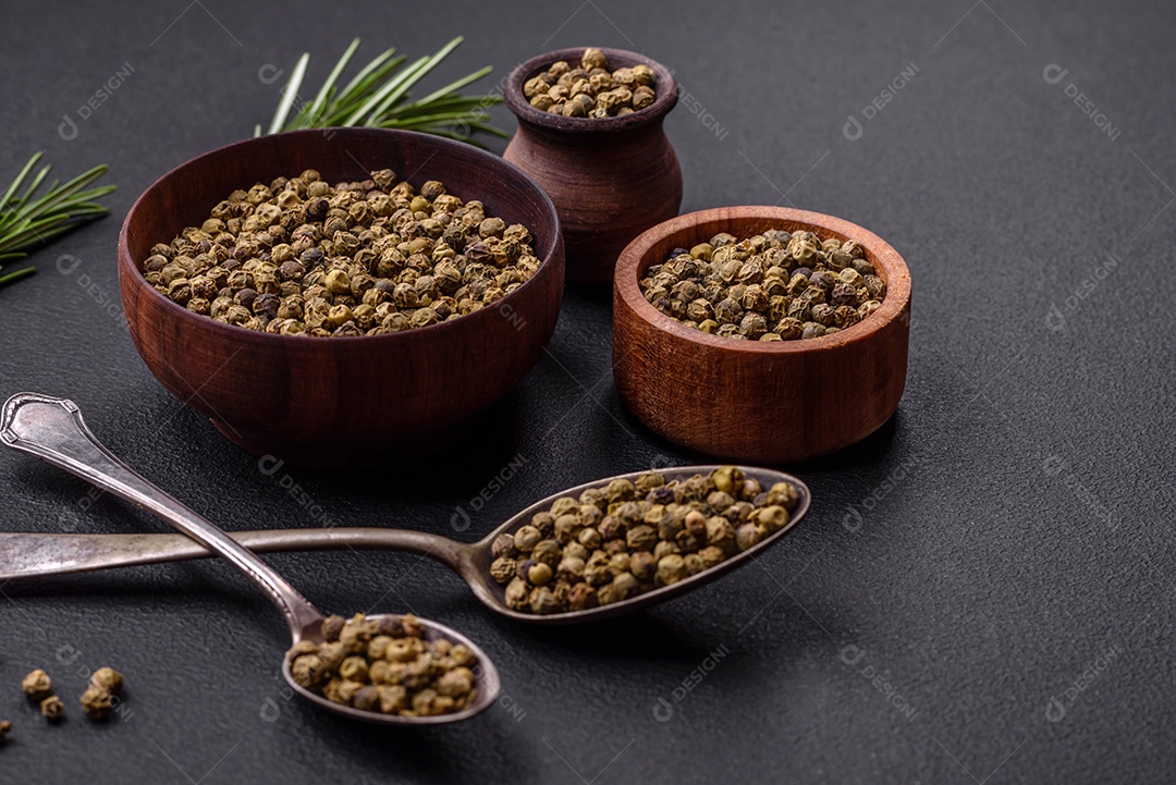 Especiarias, pimenta da Jamaica verde em uma tigela de madeira sobre um fundo preto de concreto. Cozinha asiática