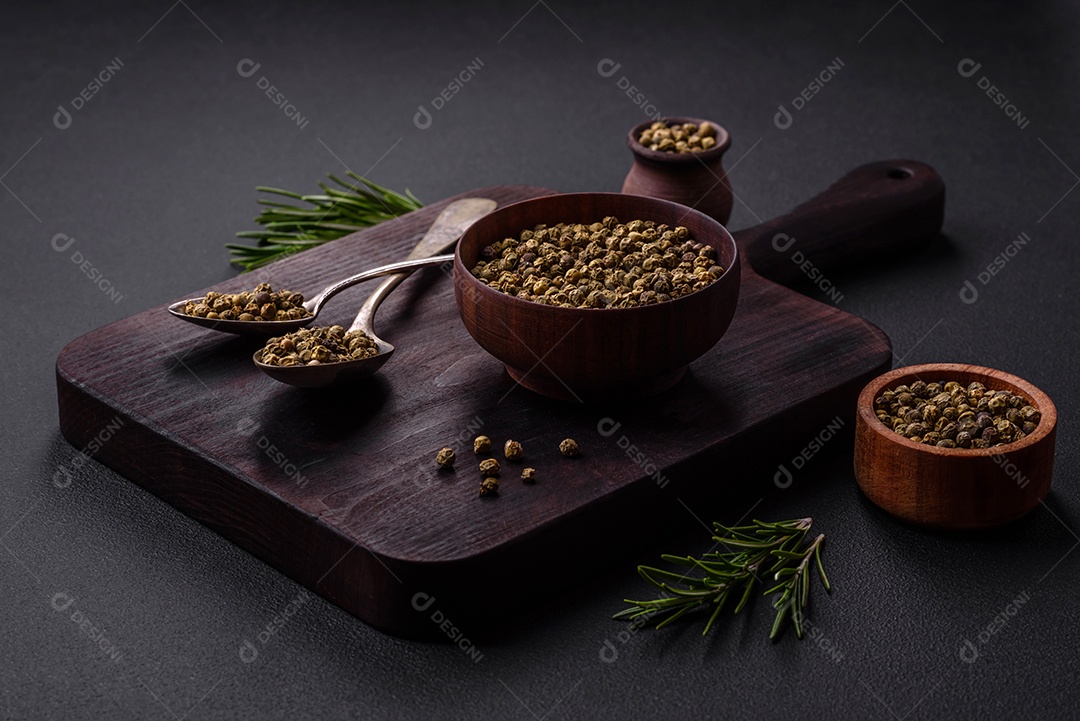 Especiarias, pimenta da Jamaica verde em uma tigela de madeira sobre um fundo preto de concreto. Cozinha asiática