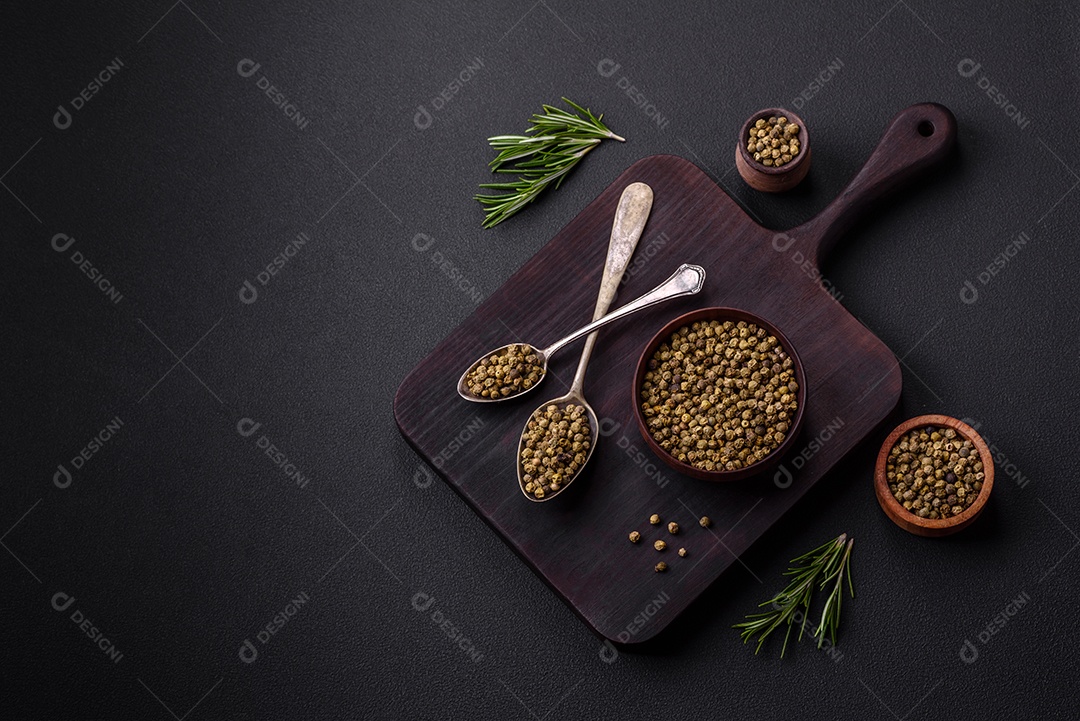 Especiarias, pimenta da Jamaica verde em uma tigela de madeira sobre um fundo preto de concreto. Cozinha asiática