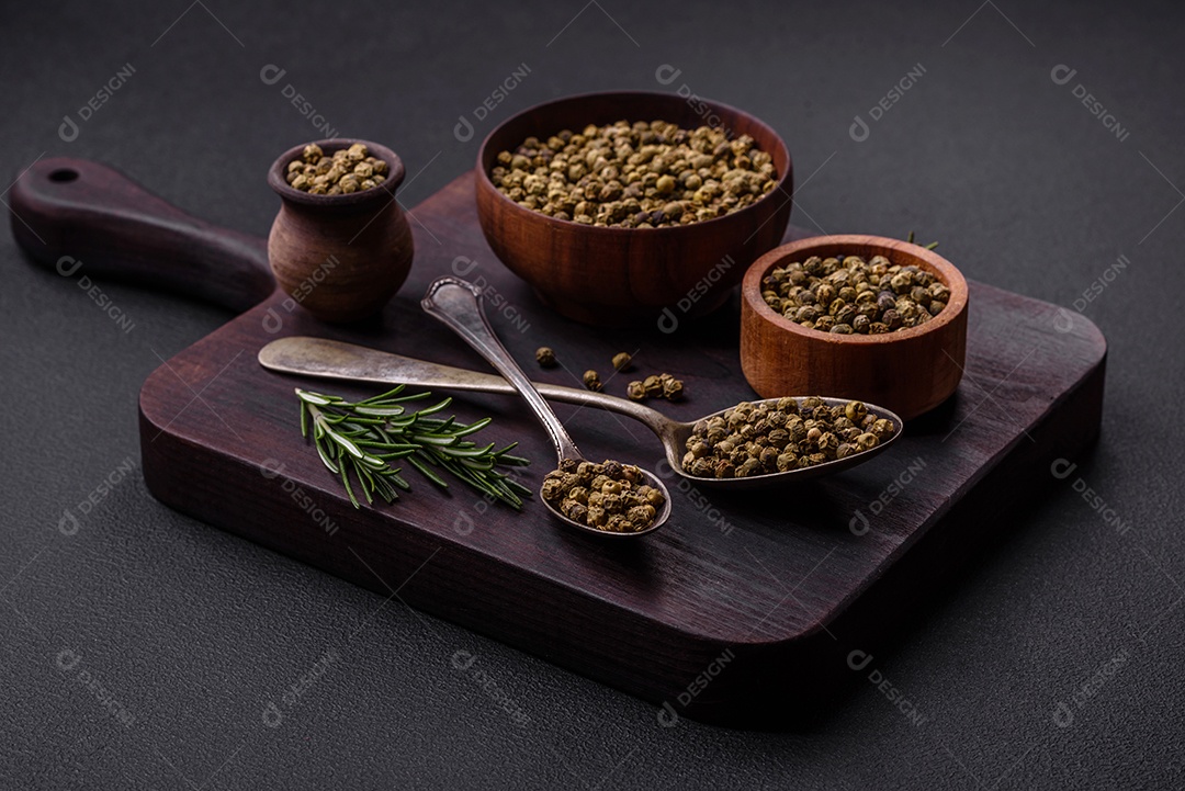 Especiarias, pimenta da Jamaica verde em uma tigela de madeira sobre um fundo preto de concreto. Cozinha asiática