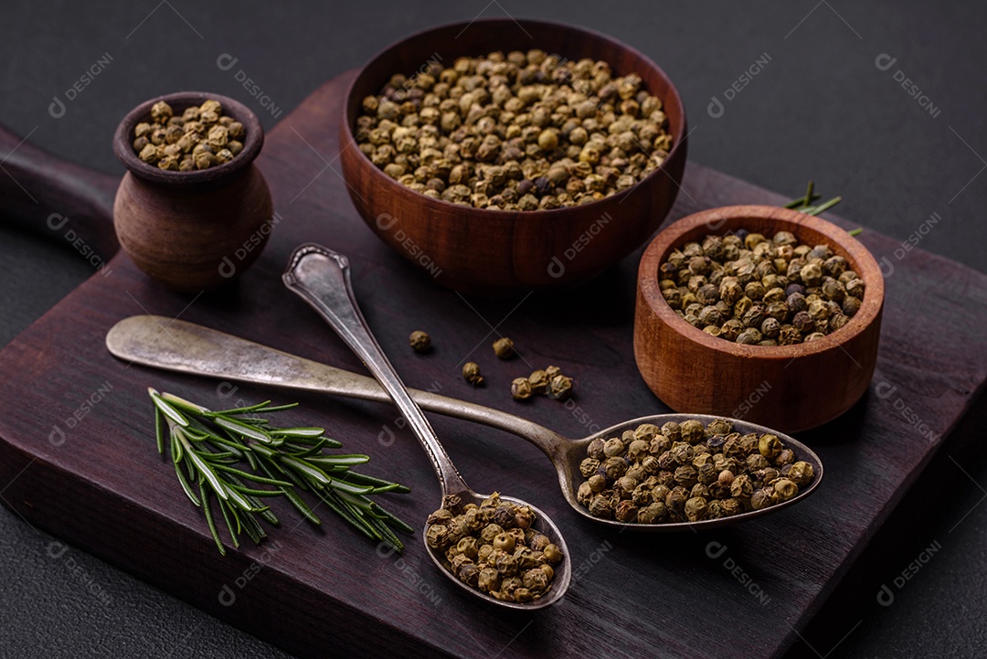 Especiarias, pimenta da Jamaica verde em uma tigela de madeira sobre um fundo preto de concreto. Cozinha asiática