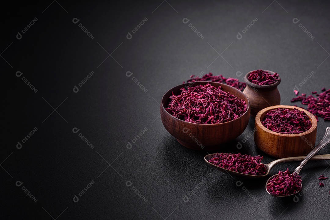 Beterrabas secas em pequenas fatias em uma tigela de madeira sobre um fundo preto de concreto. Cozinha asiática