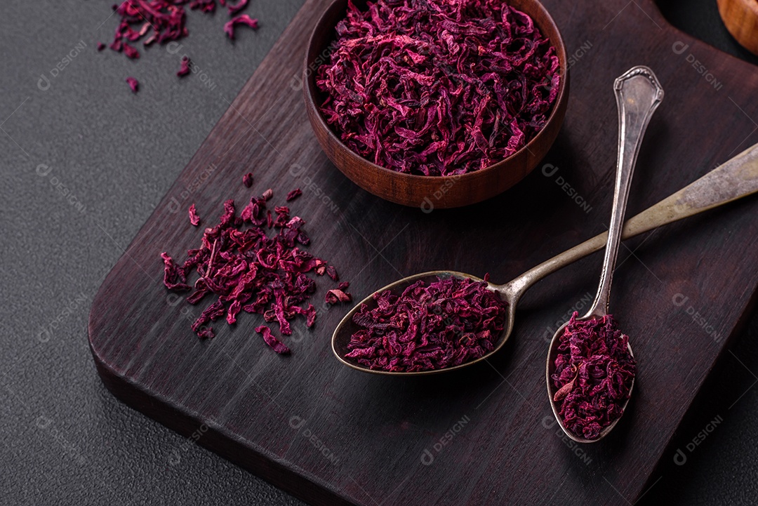 Beterrabas secas em pequenas fatias em uma tigela de madeira sobre um fundo preto de concreto. Cozinha asiática