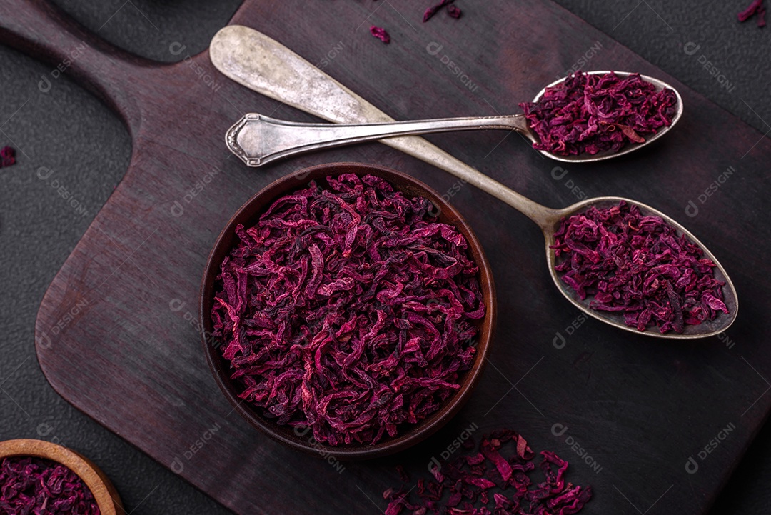 Beterrabas secas em pequenas fatias em uma tigela de madeira sobre um fundo preto de concreto. Cozinha asiática
