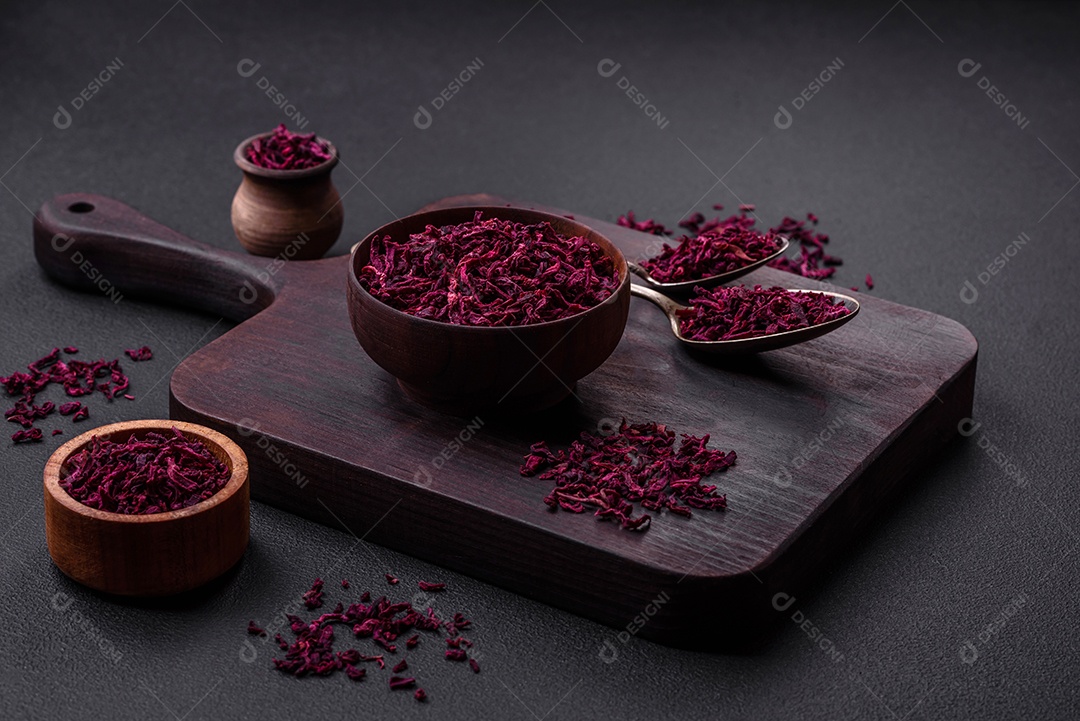 Beterrabas secas em pequenas fatias em uma tigela de madeira sobre um fundo preto de concreto. Cozinha asiática