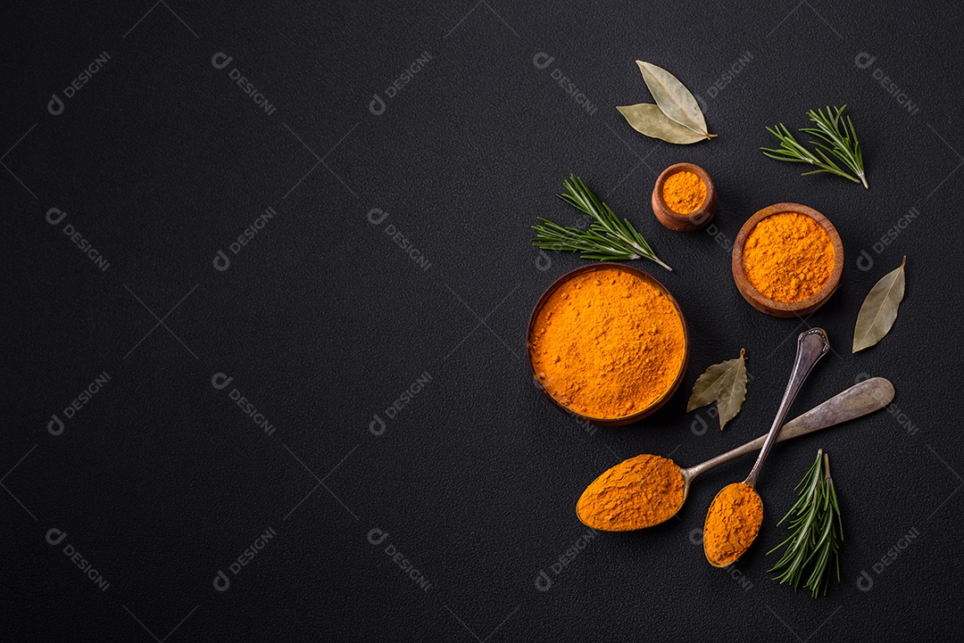 Cúrcuma amarela brilhante ou tempero de curry para preparação de alimentos asiáticos em fundo escuro de concreto
