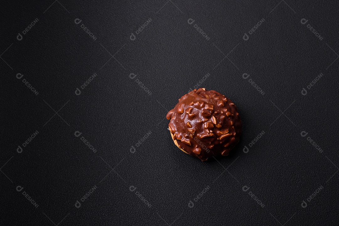 Deliciosa torta de chocolate com nozes em uma placa de cerâmica preta sobre um fundo escuro de concreto