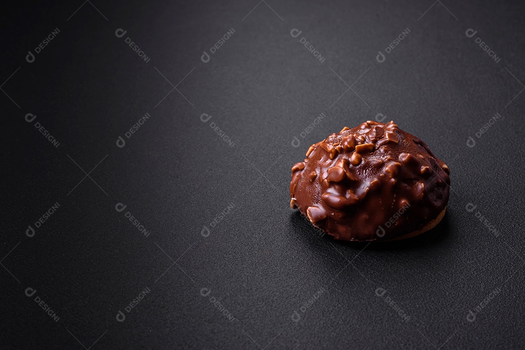 Deliciosa torta de chocolate com nozes em uma placa de cerâmica preta sobre um fundo escuro de concreto