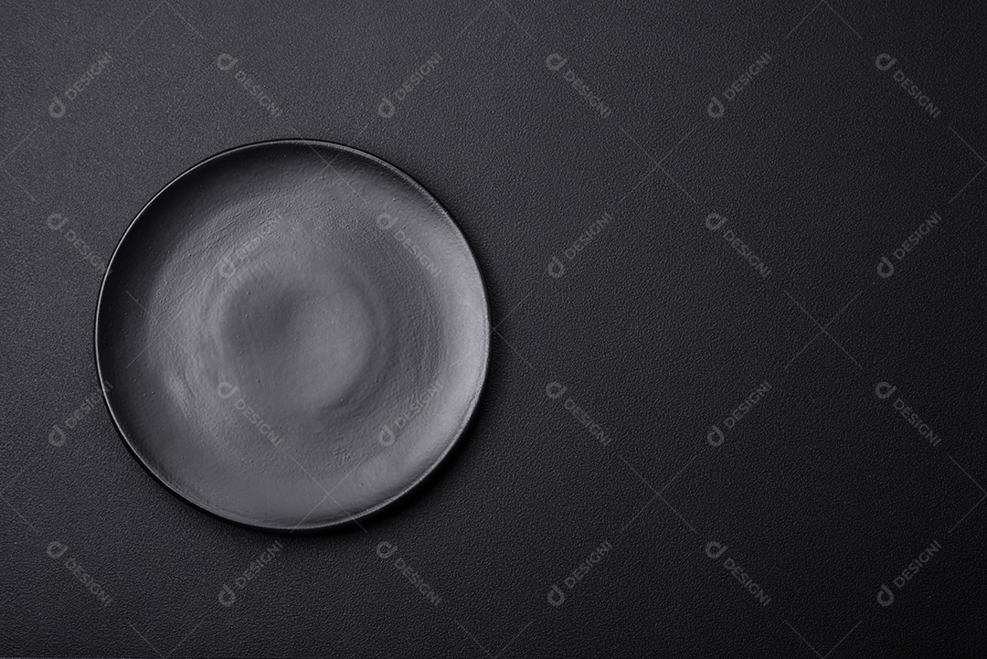 Placa redonda de cerâmica vazia em fundo de concreto texturizado escuro, preparação para o jantar
