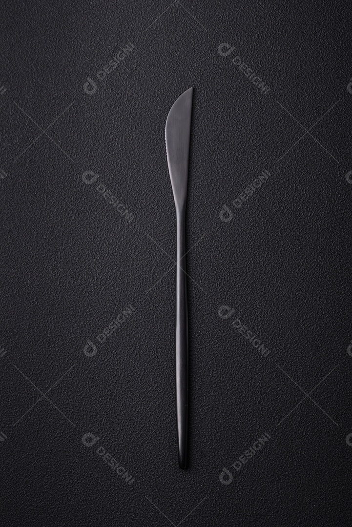 Faca de cozinha de metal em um fundo de concreto texturizado escuro. Talheres, preparação para o jantar