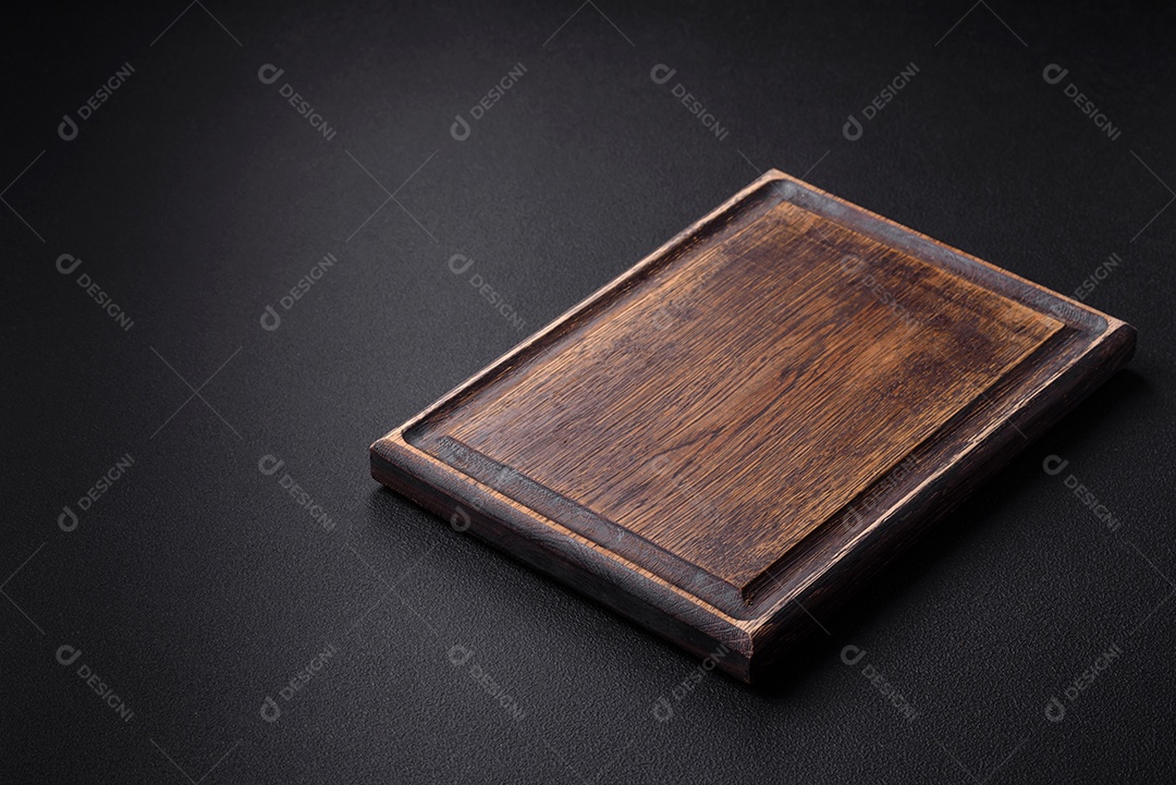 Tábua de corte de madeira vazia em fundo de concreto texturizado escuro. preparação para o jantar