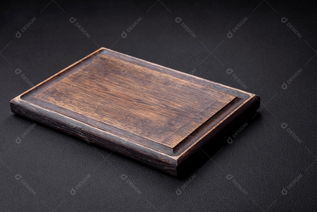 Tábua de corte de madeira vazia em fundo de concreto texturizado escuro. preparação para o jantar