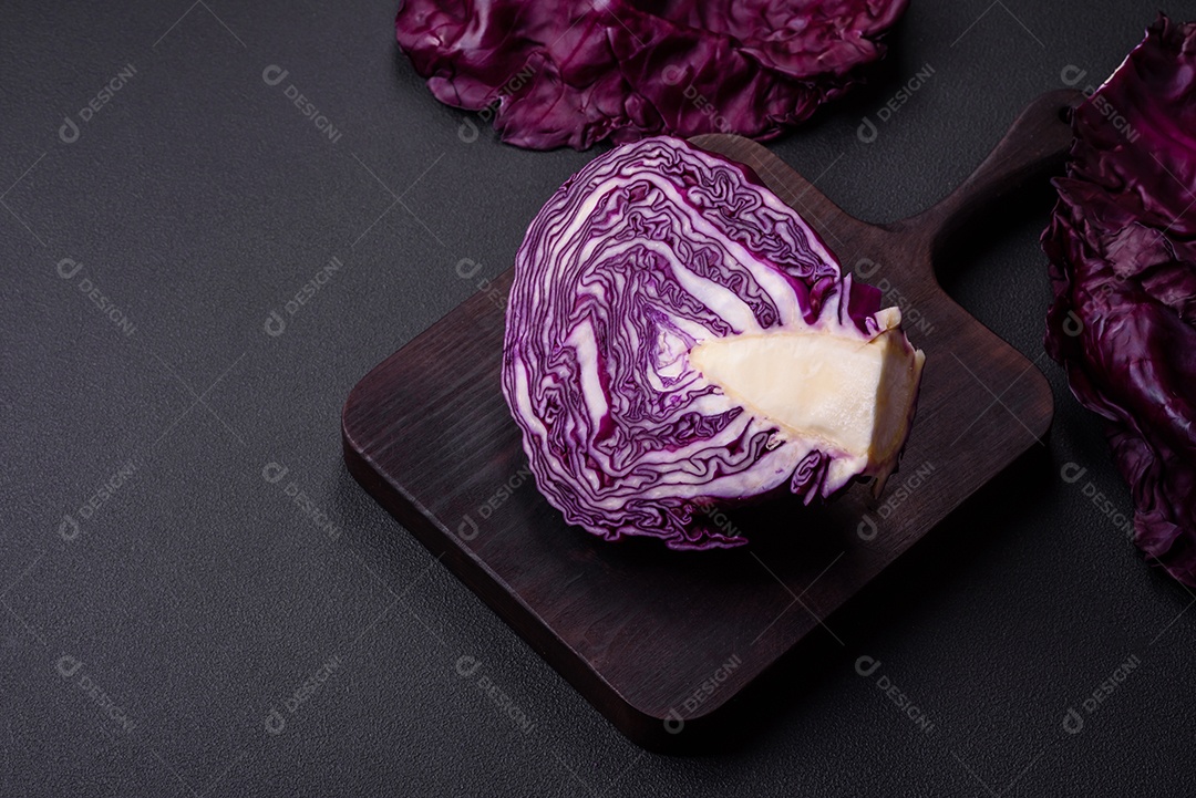 Repolho roxo lindo fresco com folhas texturizadas em um fundo escuro de concreto. Cozinha vegetariana