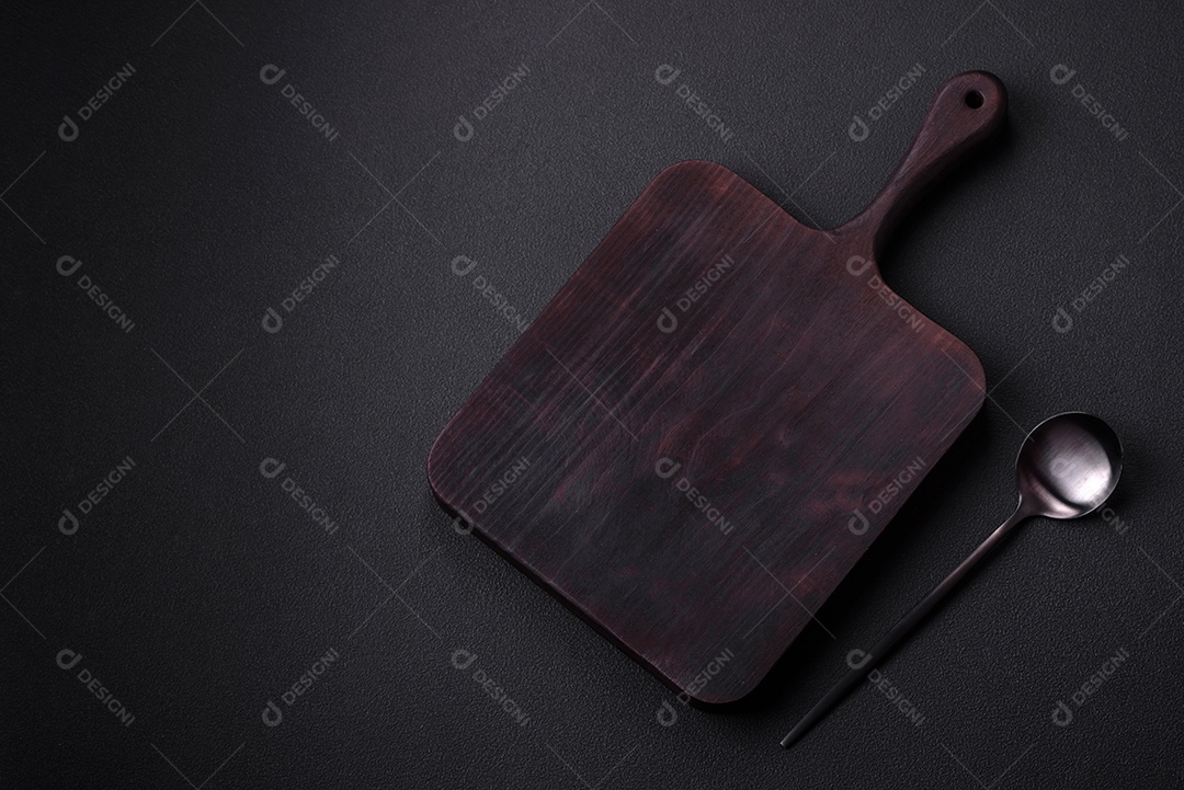 Colher de metal vazia em fundo de concreto texturizado escuro. Talheres, preparação para o jantar