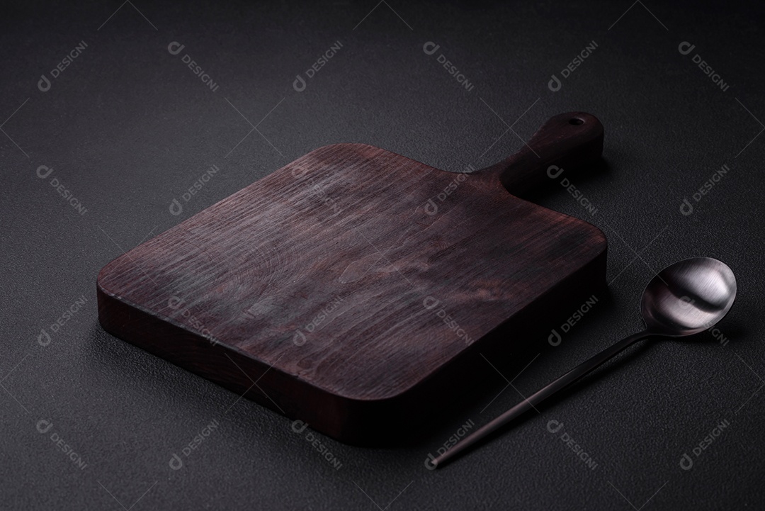 Colher de metal vazia em fundo de concreto texturizado escuro. Talheres, preparação para o jantar