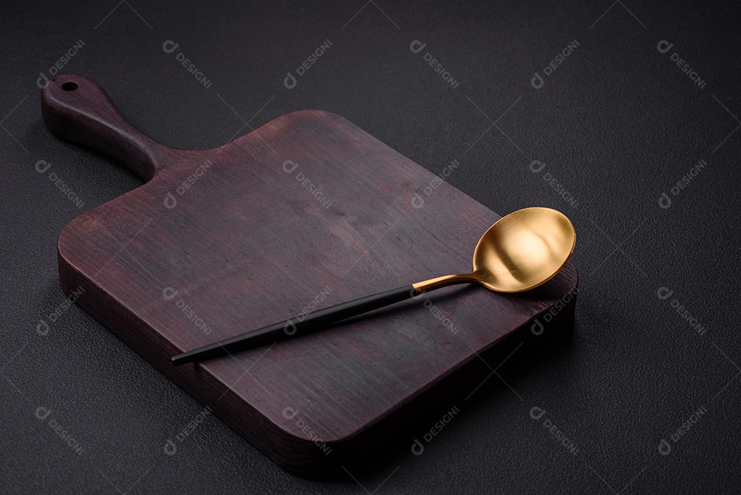 Colher de metal vazia em fundo de concreto texturizado escuro. Talheres, preparação para o jantar