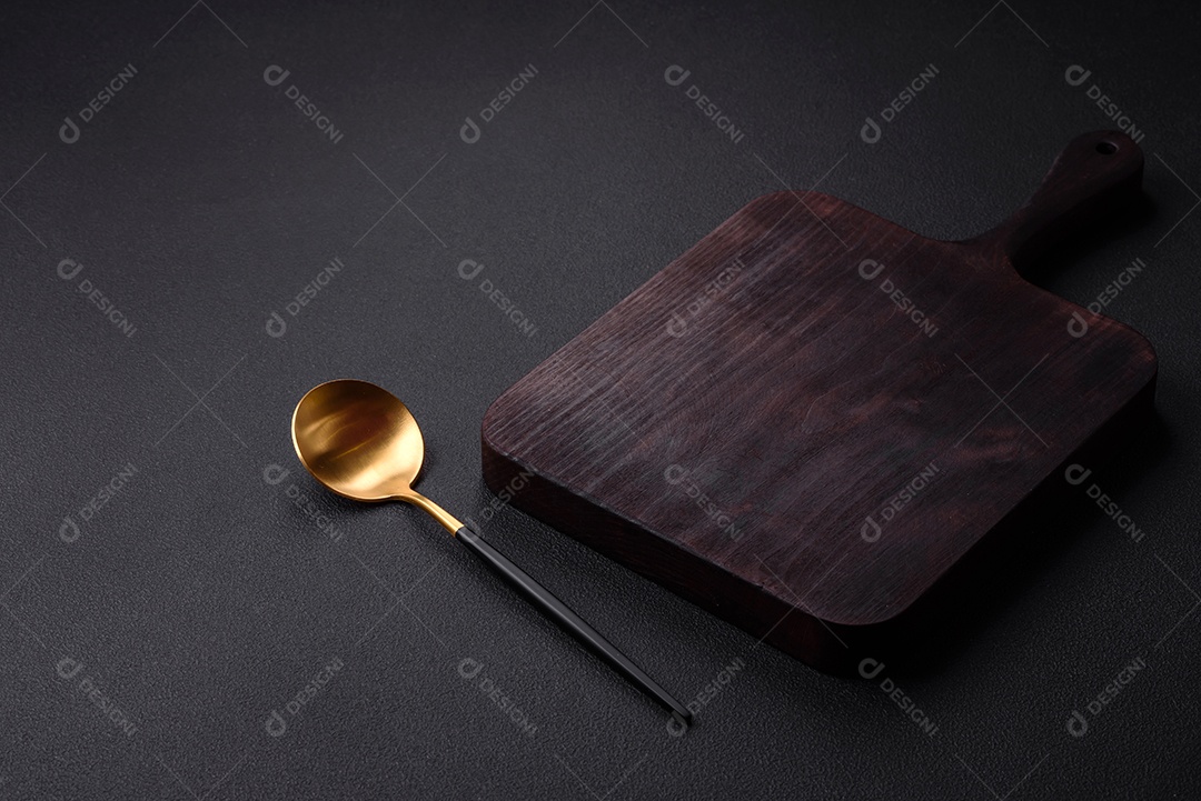 Colher de metal vazia em fundo de concreto texturizado escuro. Talheres, preparação para o jantar