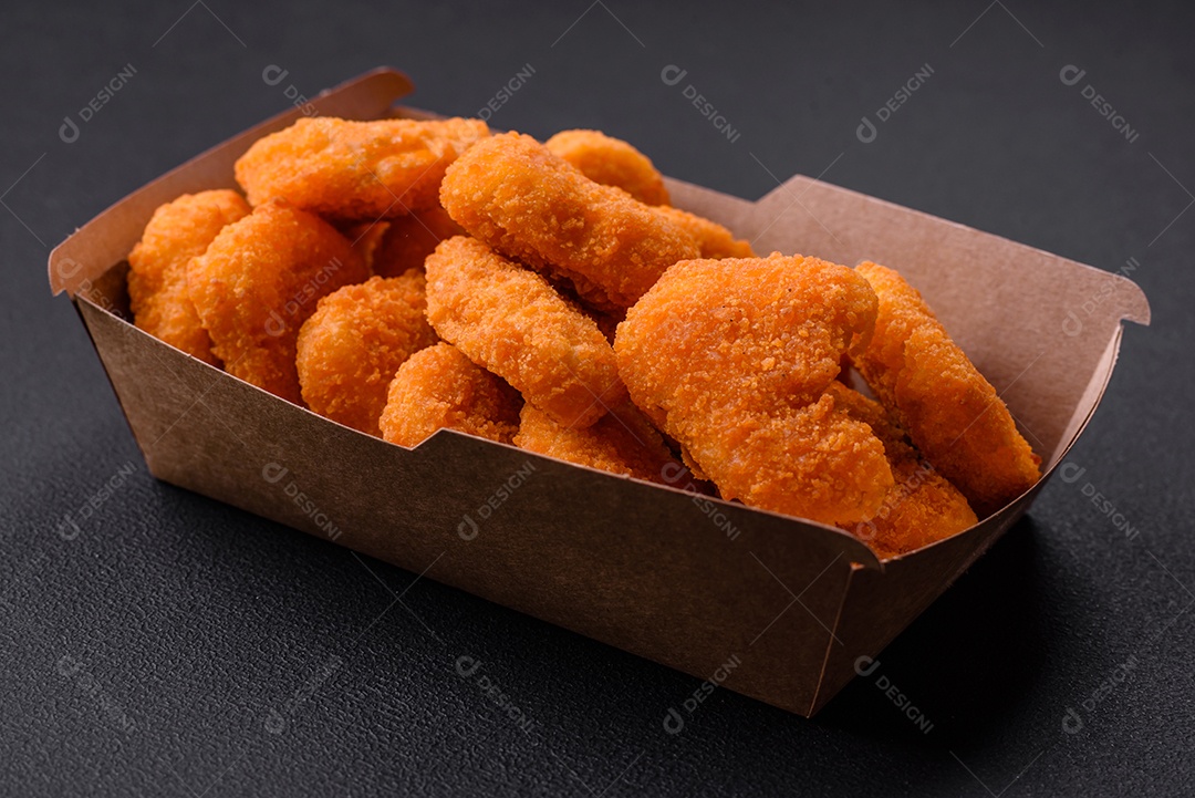 Deliciosos nuggets de frango crocantes frescos em um fundo escuro de concreto. Alimentos não saudáveis, fast food