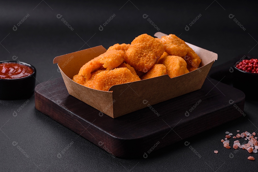 Deliciosos nuggets de frango crocantes frescos em um fundo escuro de concreto. Alimentos não saudáveis, fast food