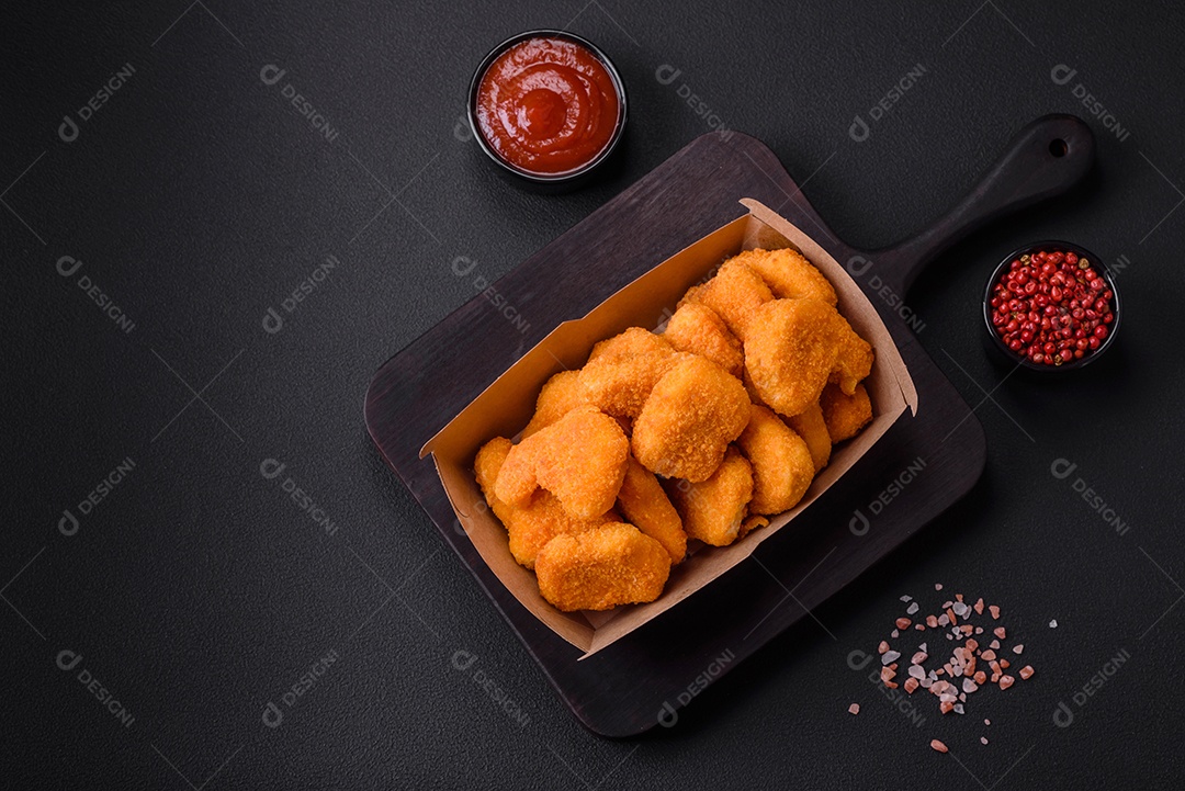 Deliciosos nuggets de frango crocantes frescos em um fundo escuro de concreto. Alimentos não saudáveis, fast food