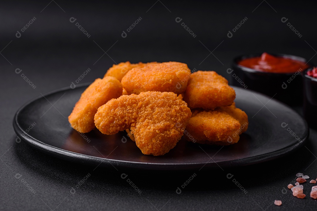 Deliciosos nuggets de frango crocantes frescos em um fundo escuro de concreto. Alimentos não saudáveis, fast food