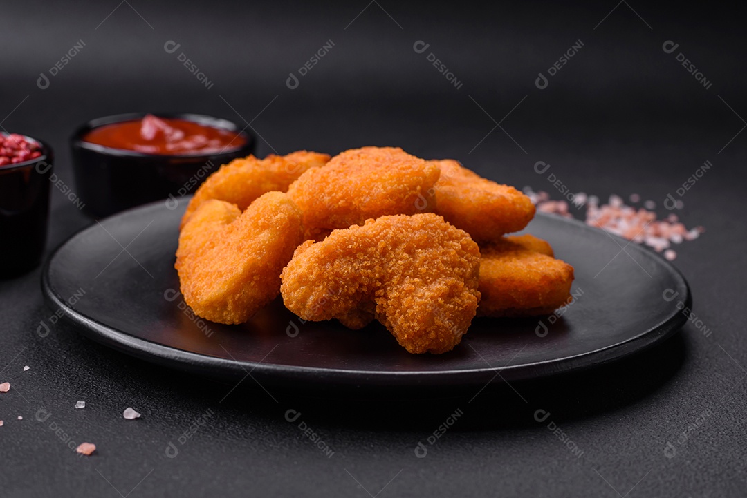 Deliciosos nuggets de frango crocantes frescos em um fundo escuro de concreto. Alimentos não saudáveis, fast food