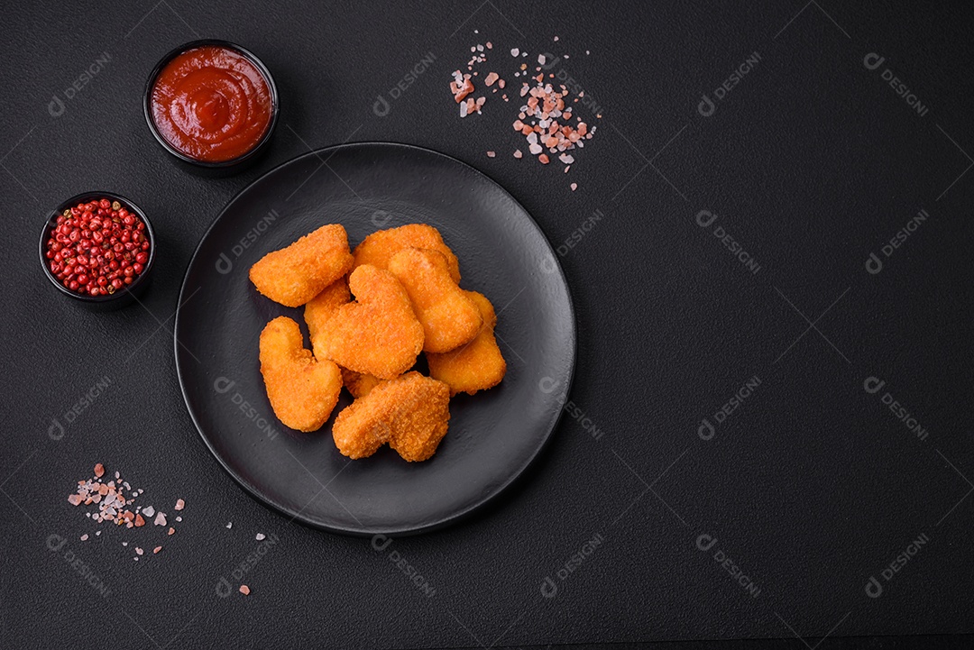 Deliciosos nuggets de frango crocantes frescos em um fundo escuro de concreto. Alimentos não saudáveis, fast food