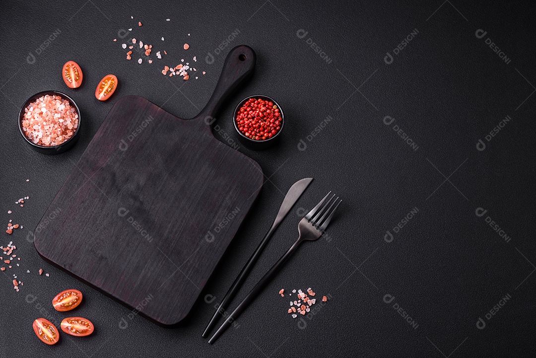 Tábua de corte de madeira vazia em fundo de concreto texturizado escuro. Talheres, preparação para o jantar