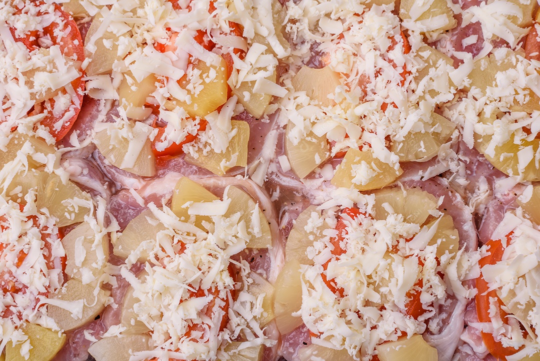 Um prato composto por carne, tomate, abacaxi, queijo, especiarias e ervas em pergaminho em uma assadeira. Preparando alimentos para assar no forno