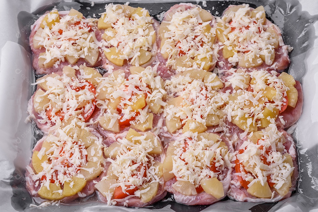 Um prato composto por carne, tomate, abacaxi, queijo, especiarias e ervas em pergaminho em uma assadeira. Preparando alimentos para assar no forno