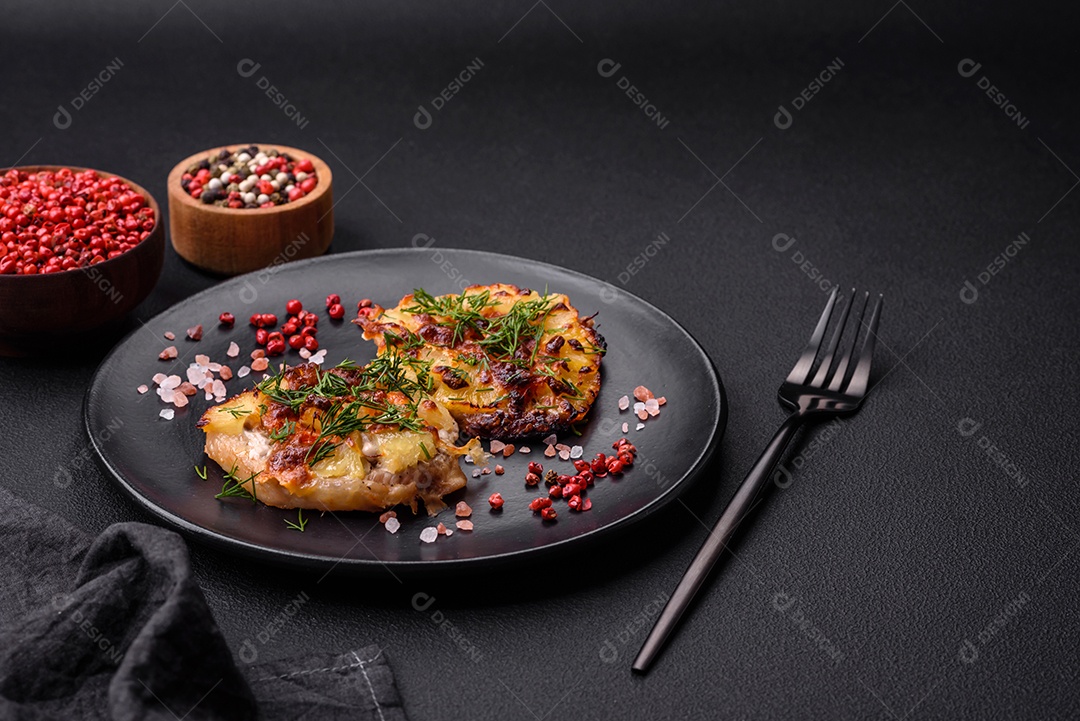 Carne assada no forno com abacaxi, tomate, queijo, especiarias e ervas em uma placa de cerâmica preta sobre fundo escuro de concreto