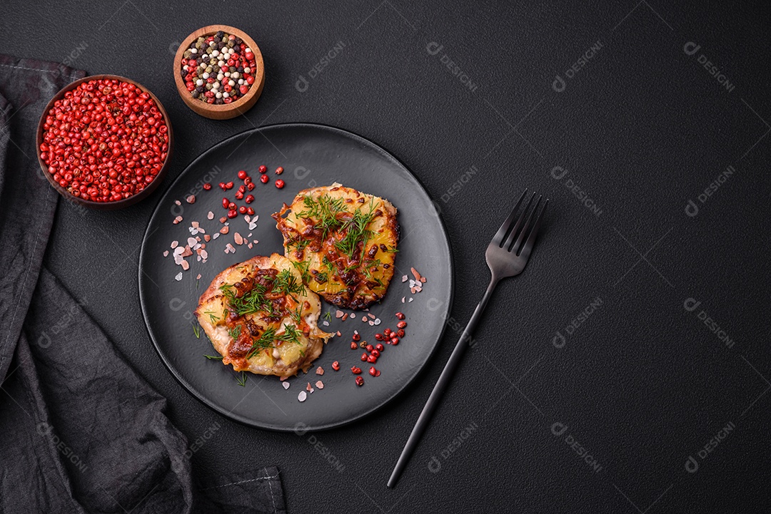 Carne assada no forno com abacaxi, tomate, queijo, especiarias e ervas em uma placa de cerâmica preta sobre fundo escuro de concreto