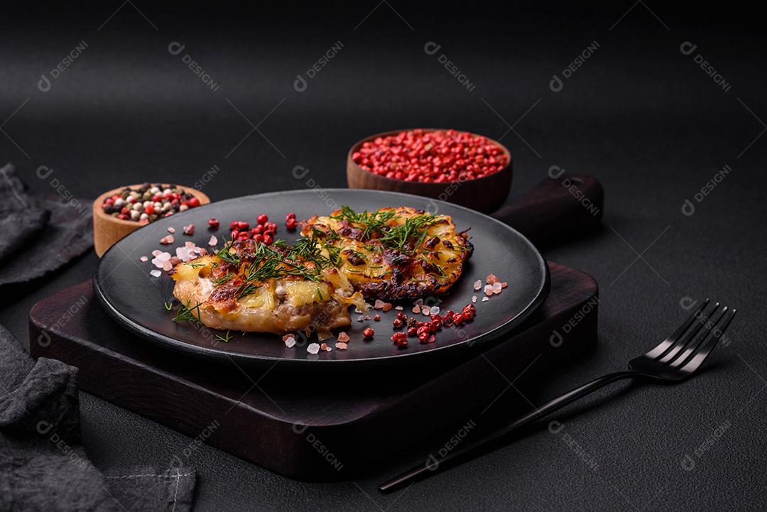 Carne assada no forno com abacaxi, tomate, queijo, especiarias e ervas em uma placa de cerâmica preta sobre fundo escuro de concreto