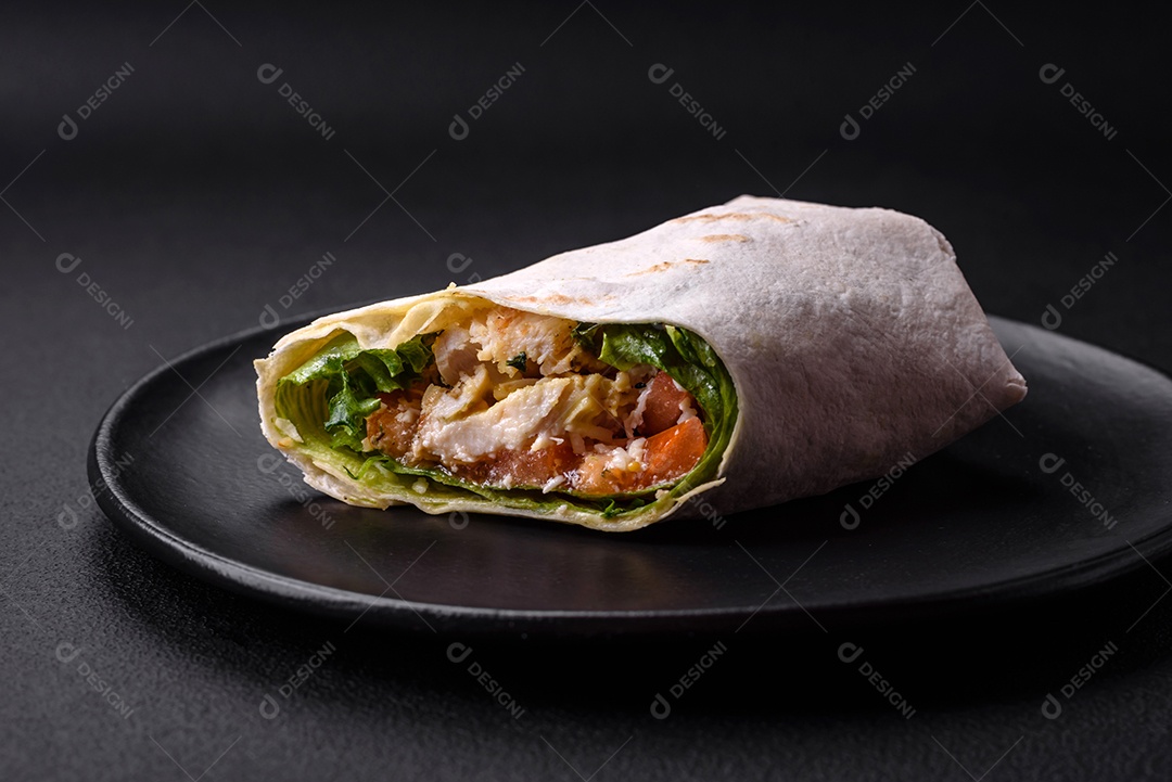 Delicioso pão fresco com frango, tomate, alface e pepino em pão pita sobre um fundo escuro de concreto