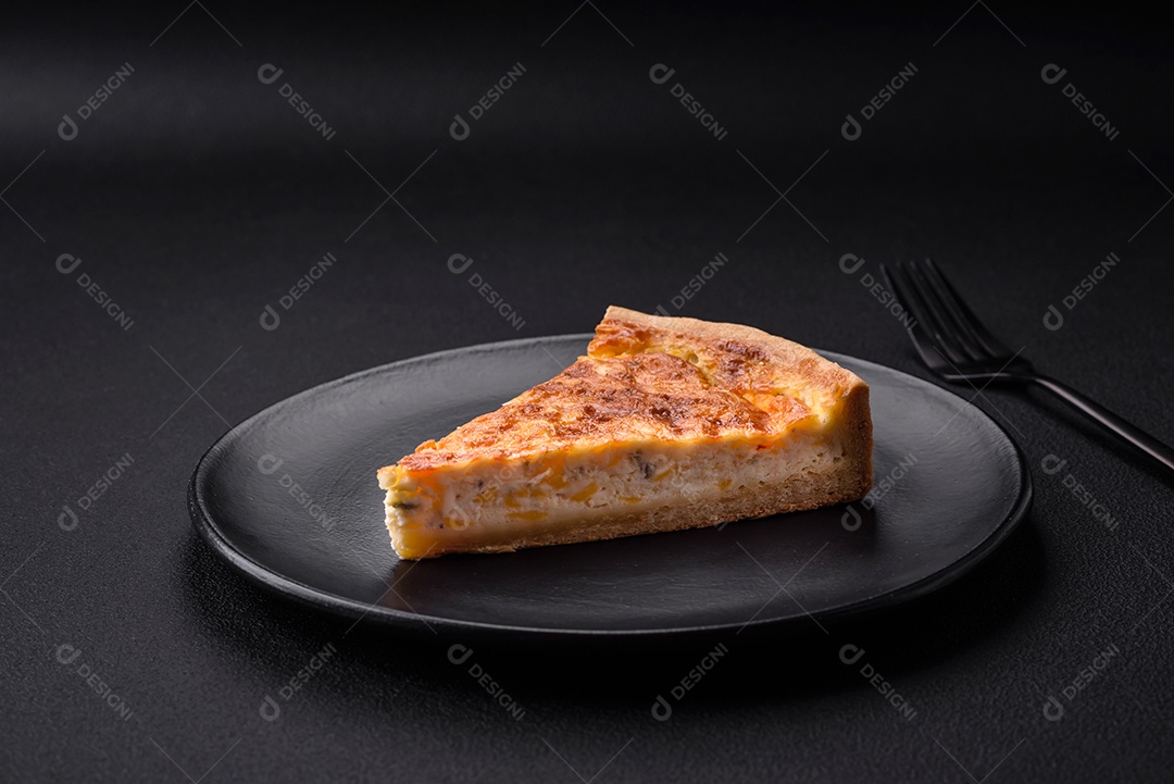 Linda e deliciosa torta de quiche com quatro tipos de queijo com especiarias e ervas em um fundo escuro de concreto