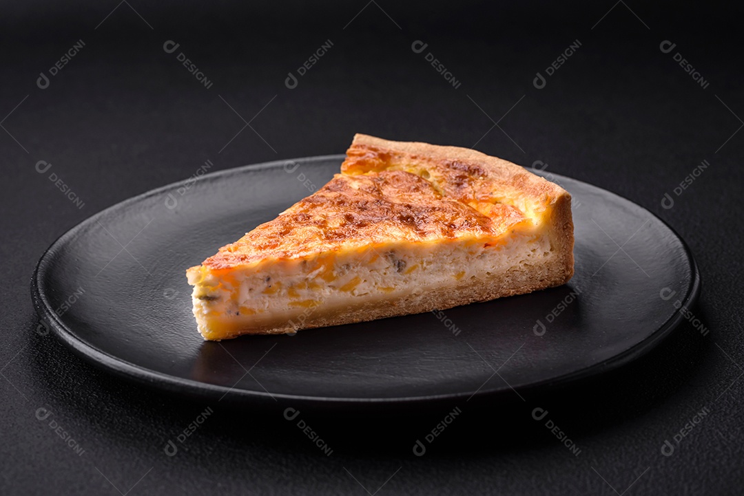 Linda e deliciosa torta de quiche com quatro tipos de queijo com especiarias e ervas em um fundo escuro de concreto