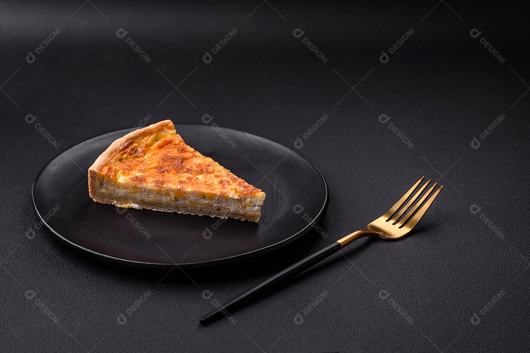 Linda e deliciosa torta de quiche com quatro tipos de queijo com especiarias e ervas em um fundo escuro de concreto